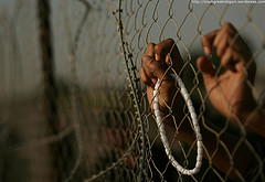 A Palestinian pilgrim holds prayer beads against a fence as they wait to pass from Gaza through the Rafah border crossing to Egypt for the upcoming Eid al-Adha festival, in Rafah, southern Gaza Strip, Tuesday, Nov. 24, 2009